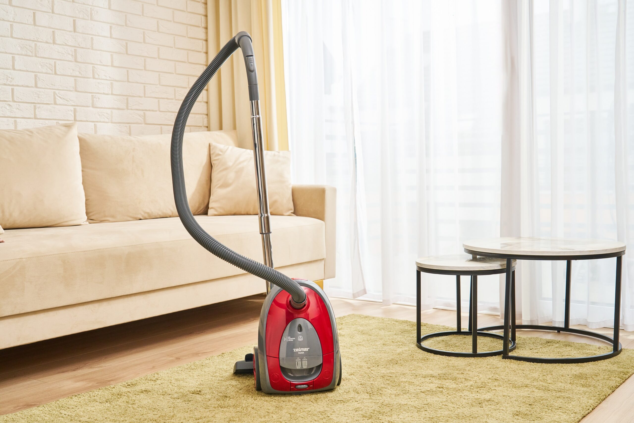 Czerwony odkurzacz Zelmer w salonie